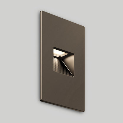 The Dark Sky LED Step Light is a sleek, rectangular, bronze fixture with a small square cutout that reveals an illuminated, ribbed interior. Mounted on a plain light gray wall, it’s weather-resistant—ideal for modern spaces.