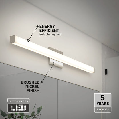 The Mylo LED Vanity Light 36IN, featuring a brushed nickel finish, is mounted above a bathroom mirror. Text highlights its energy efficiency, integrated LED technology, and five-year warranty. Some greenery appears at the bottom.