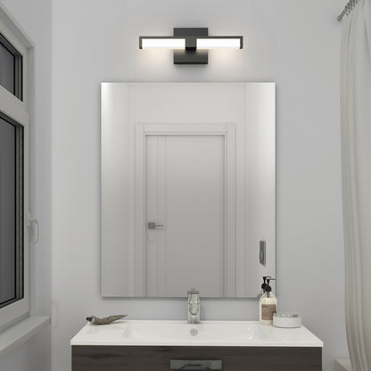 A modern bathroom features a rectangular mirror above a white sink, with a soap dispenser and toothbrush holder on the dark vanity. Above the mirror is the Tivoli 14'' LED Vanity Light. A window with a curtain is visible on the left.