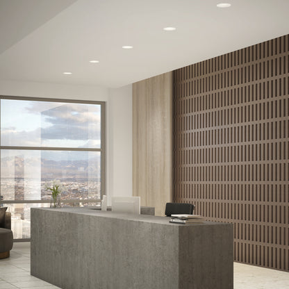 Modern office reception with a concrete front desk, black chair, computer, and flower vase. Subtle lighting from the Skyview 4in Regressed Round, 5CCT LED. Large window shows city and mountains; wooden slats accent the back wall.