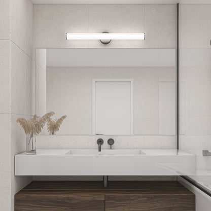 A modern bathroom with a large mirror, white rectangular sink, black minimalist fixtures, wooden cabinet, glass container of dried plants, and a Kalio Indoor LED Wall Sconce 32" mounted above the mirror.