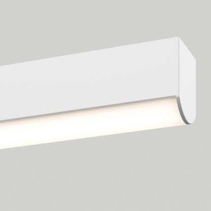 A close-up of the Delta LED Linear Pendant 36IN, a modern white rectangular fixture mounted on a light gray wall, emits a soft, even glow.