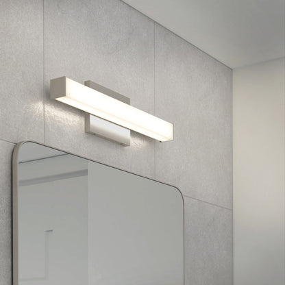 The Mylo LED Vanity Light 16IN, a modern rectangular fixture, is mounted above a large mirror on a gray tiled bathroom wall and emits a soft white glow.