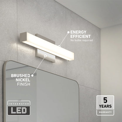 The Mylo LED Vanity Light 16IN, a modern rectangular fixture with a brushed nickel finish, is mounted above the bathroom mirror and features energy efficiency plus a 5-year warranty.