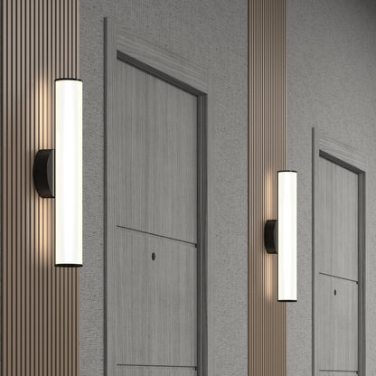 Two Kalio Indoor LED Wall Sconce 18" fixtures are mounted between light gray, wood-paneled doors and beige textured walls in a hallway, adding a modern, minimalist touch.