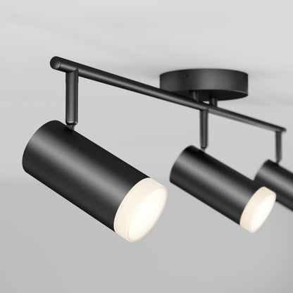 Close-up of the 32" Blake 3L tracklight, a modern black LED fixture with three illuminated cylindrical spotlights, mounted on a white ceiling for stylish accent lighting.