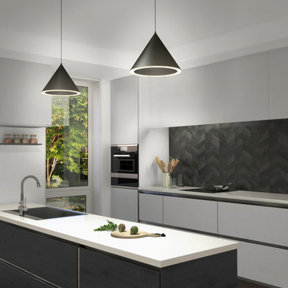 Modern kitchen with white cabinets, black chevron backsplash, island with white countertop, built-in oven, sink, utensils, a Denali LED Pendant 3CCT light fixture, and a large window displaying green trees outside.