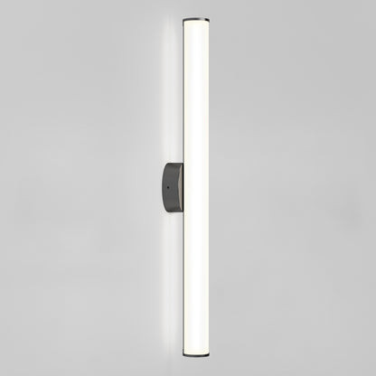 The Kalio Indoor LED Wall Sconce 32" features a sleek, minimalist design with a long frosted glass shade, emitting soft white light from its dark wall mount. Suitable for 0-10V dimming, 120-277V, it’s shown against a plain light gray background.
