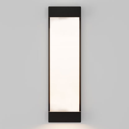 The Glacier Pro Integrated LED Outdoor Wall Light features a rectangular black frame at the top and bottom with a frosted white center, mounted on a light gray wall and emitting a soft, inviting glow.
