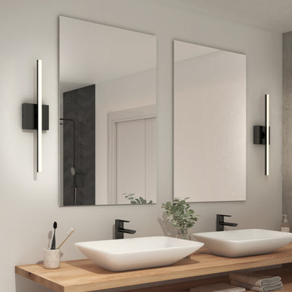 Modern bathroom with two rectangular mirrors above a wooden countertop featuring two white vessel sinks, black faucets, and Delta Led Indoor/Outdoor Wall Light 21'' on either side. A small plant and toiletries decorate the counter.