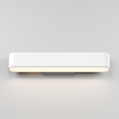 The Willow LED Vanity 3CCT Light is a modern rectangular wall sconce with rounded edges, mounted on a light gray wall and casting a soft, warm adjustable glow—ideal as a bathroom mirror light with customizable color balance.