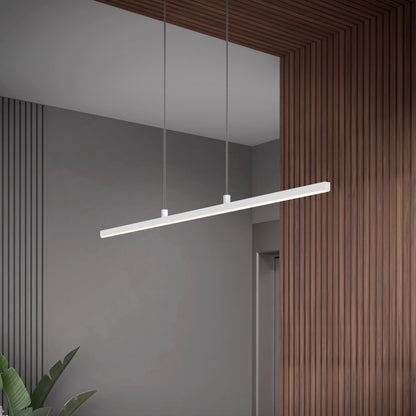 The Delta LED Linear Pendant 36IN, a modern minimalist white fixture, hangs from the ceiling in a room with gray walls, wood paneling accents, and a green plant in the corner.