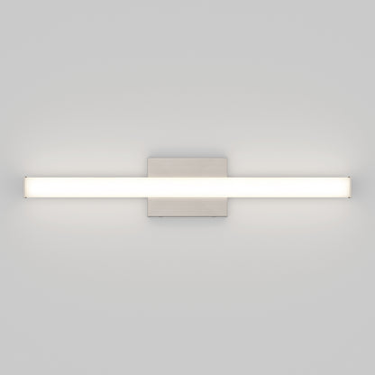 The Mylo LED Vanity Light 24IN is a modern wall-mounted fixture featuring a horizontal rectangular light bar and central square metal base, emitting soft white light against a light grey wall.