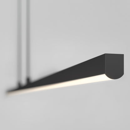 The Delta Pendant 48IN 3CCT Pro, a sleek and modern black linear fixture, hangs from the ceiling against a white background, casting a soft, even glow below.