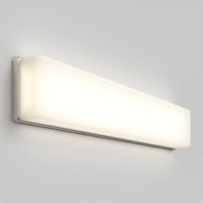 The Aster 27in Energy Star LED Vanity Light is a modern, rectangular wall-mounted fixture with a frosted white cover that emits a soft, even glow against a light gray wall.