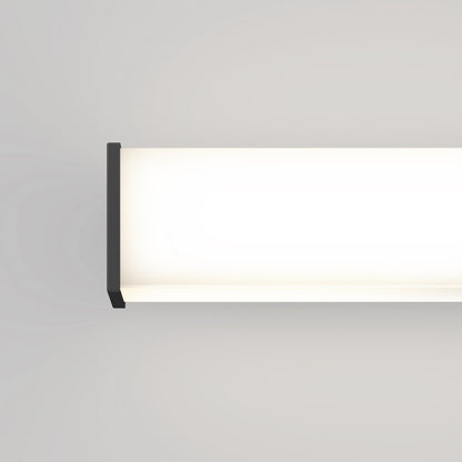 The Mylo LED Vanity Light 16IN is a modern rectangular wall-mounted fixture with black end caps, casting a soft, bright white glow on a light gray wall. Only half of the fixture appears in the image.
