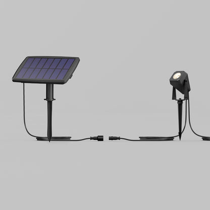 The Verner - Solar Landscape Single CCT LED 4-pack features solar panels on stakes connected by cables to outdoor spotlights, all ground-mounted and shown against a plain gray background.