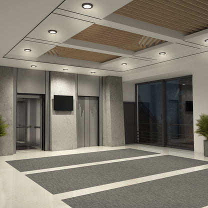 Modern building lobby with large windows, two elevators, a wall-mounted TV, gray rugs on glossy floor, concrete pillars, and Skylight Pro 5 3K LED Flat Panel Lights. A potted plant sits in the corner near the glass doors.