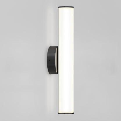 The Kalio Indoor LED Wall Sconce 18" features a vertical frosted LED light tube and round matte black base, mounted on a plain light gray wall. Dimmable, compatible with 0-10V and 120-277V systems.