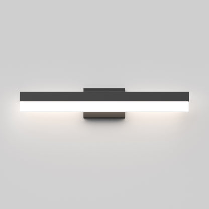 The Mystic LED Vanity Light is a modern, rectangular wall-mounted fixture with a sleek black frame and white illuminated panel, casting soft light against a light gray wall.
