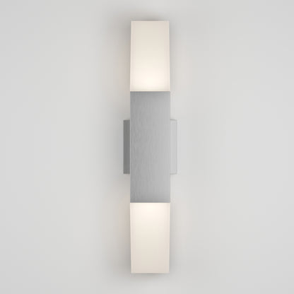 The Lennox Pro LED Outdoor Wall Light features a brushed metal center with two rectangular white diffusers above and below, casting soft illumination on a light gray wall.
