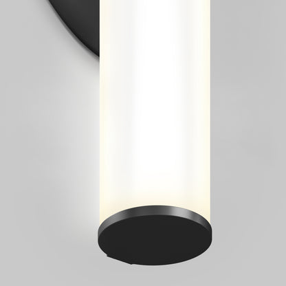 A close-up of the Kalio Indoor LED Wall Sconce 18" (0-10V, 120-277V) features a modern tubular design with matte black accents, casting soft white light against a light gray background.