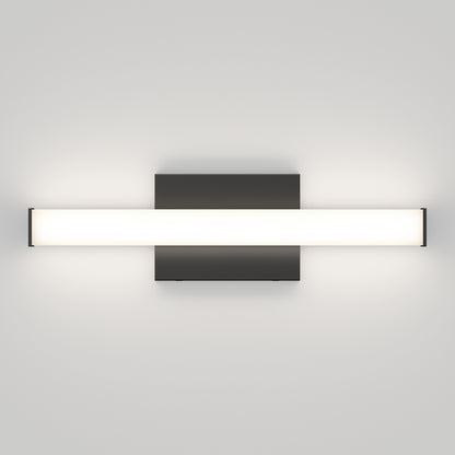 The Mylo LED Vanity Light 16IN features a minimalist wall-mounted design with a rectangular black base and a long frosted glass shade, casting a soft, even white glow against a light gray wall.