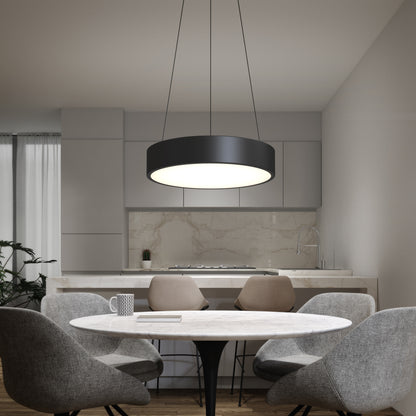 A modern kitchen features a round marble dining table with four gray chairs, while the Concerto LED Pendant in black hangs above. Minimalist cabinets and a marble backsplash complete the sleek background.