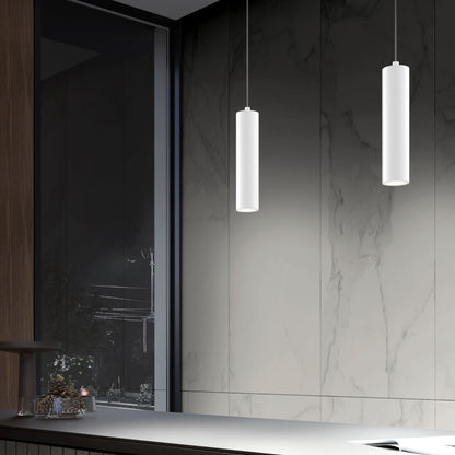 Modern kitchen with marble walls, a reflective countertop, large window overlooking the night, and two sleek Damian LED Cylinder Pendants in white hanging from the ceiling.