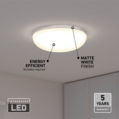 The Knox LED 13In Energy Star Flush Mount, shown in a modern room, features an energy-efficient integrated LED, matte white finish, flush-mount design, and comes with a 5-year warranty.