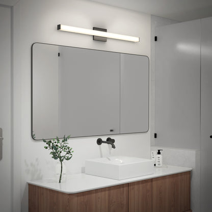 A modern bathroom with a large rectangular mirror, sleek sink, wall-mounted black faucet, wooden vanity, plant in a glass vase, soap dispenser, and the Mylo LED Vanity Light 36IN installed above the mirror.