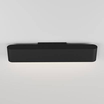 The Willow LED Vanity 3CCT Light features a modern black design that emits soft white light downward onto a plain white wall, making it perfect as a bathroom mirror light.