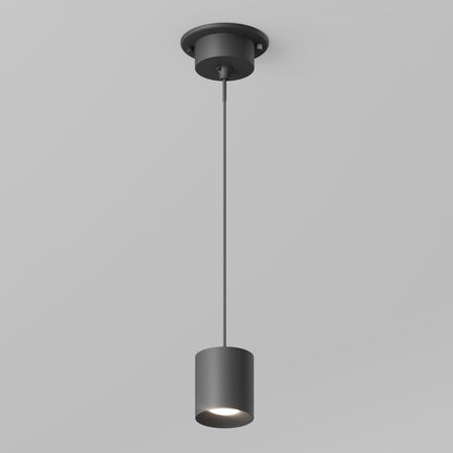 The Beam Pro 4 Integrated LED 2-IN-1 Ceiling Mount Pendant features a modern black cylindrical shade, suspended by a thin cord from the ceiling. Set against a light gray background, the turned-on LED softly illuminates the area below.