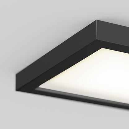 A close-up view of the Skylight Pro Square 7in 3K LED Flush Mount, featuring a modern black frame and bright diffused panel, installed on a white ceiling.