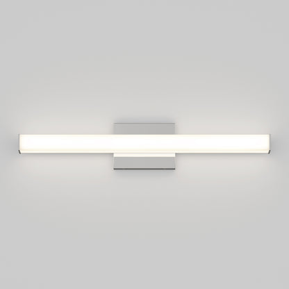 The Mylo LED Vanity Light 24IN is a modern, wall-mounted fixture with a horizontal rectangular design. It emits a soft white glow and is attached to a square metal base on a light gray wall.