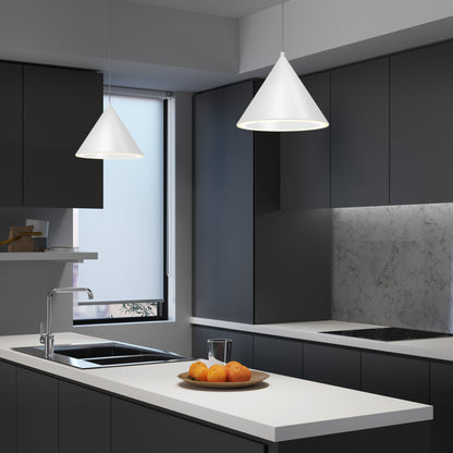 A modern kitchen with dark cabinets, white countertops, a Denali LED Pendant 3CCT, a marble backsplash, a sink, a glass of water, and a plate of oranges on the counter. Natural light streams in through the window.