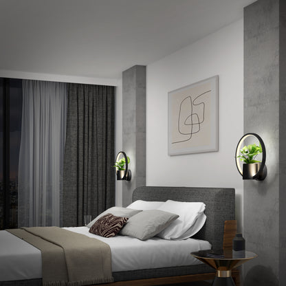 Modern bedroom with a gray upholstered bed, white bedding, and accent pillows. Two Halo Planter LED wall sconces with small potted plants flank the bed. Abstract art hangs above; large window with dark curtains is on the left.