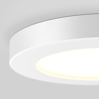 A close-up of the 5" LED Skylight with 3 colour trim rings, illuminated and mounted on a smooth, light gray ceiling.