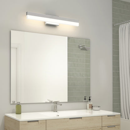 A modern bathroom features a large mirror above a light wood vanity with a chrome faucet, accented by the Mystic LED Vanity Light. The wall is tiled light green, and a shower with a white curtain appears to the right.