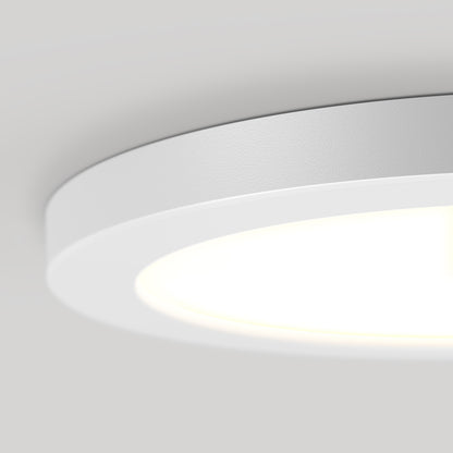 Close-up of the 9" LED Skylight with 3 colour trim rings, featuring a modern circular design, white frame, and soft even glow. Adjustable colour-balance allows customizable ambiance on a plain light gray ceiling.