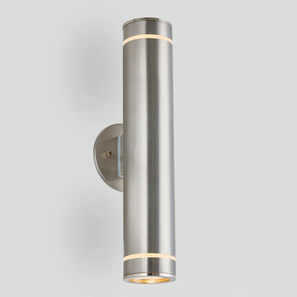 The C7 Pro Outdoor LED Wall Light is a modern cylindrical fixture with two illuminated ends, mounted vertically on a round metal base against a light gray background.