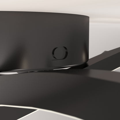 Close-up of the Dillon LED Flush Mount Noir ceiling fan, highlighting the sleek black central hub and circular detail, with blades extending outward against a softly lit, minimalistic background.