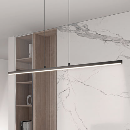 The Delta LED Linear Pendant 36IN, a modern and minimalist black fixture, hangs from the ceiling in a room featuring white marble walls and wooden shelving.