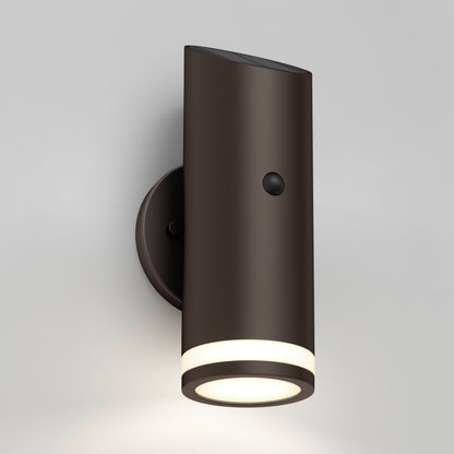 The Alba Outdoor Solar Light / Motion Sensor is a modern cylindrical wall fixture with a dark brown finish, round base, glowing ring at the bottom, and a front motion sensor for enhanced outdoor lighting.