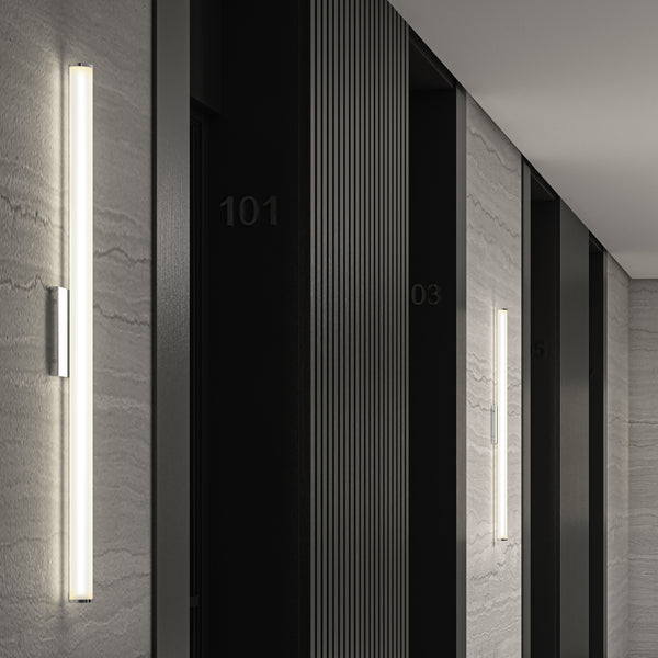A modern hallway features gray marble walls, vertical black paneling, and sleek Nuvo LED 36in Energy Star Vanity Lights. Room numbers 101 and 103 appear on dark doors, enhancing the minimalist contemporary vibe.