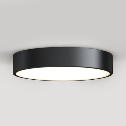 The Concerto LED Flush Mount is a modern, round black ceiling light with a flat, wide design and a bright white illuminated center, shown mounted on a plain white ceiling.