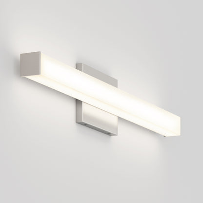 The Mylo LED Vanity Light 24IN, a modern rectangular wall-mounted fixture with a brushed metal finish, is illuminated against a plain white wall.