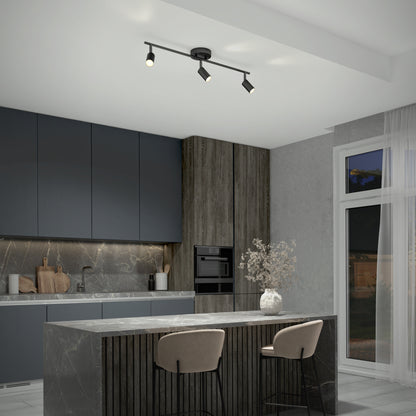 Modern kitchen with dark cabinets, marble island with two beige chairs, built-in oven, under-cabinet lighting, a vase of dried flowers on the island, and a 32" Rowen 3L tracklight. Large window features sheer curtains.