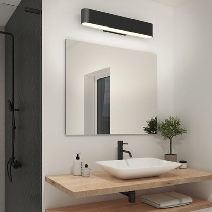 Modern bathroom featuring a square mirror, Willow LED Vanity 3CCT Light, vessel sink with black faucet, soap dispensers, small potted plant, and folded towels on a wooden countertop. Glass shower with black showerhead is seen on the left.