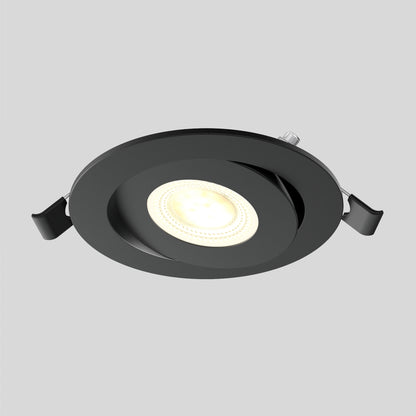 The Skyview 4in Gimbal Round, 5CCT LED is a black recessed fixture with adjustable colour temperature and two side clamps, shown on a gray background. It emits a soft, warm glow and meets JA8-2022 compliance standards.